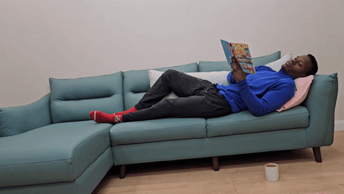 Man Laying on Couch Reading Magazine