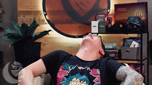 Man Laying on Couch With Magic the Gathering Cards