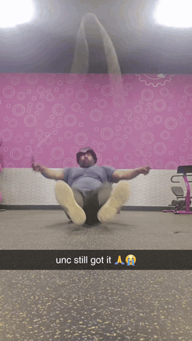 Man Laying on Floor by Pink Wall with Circles