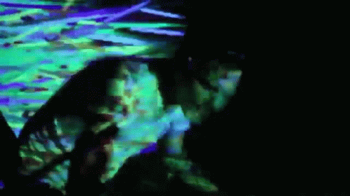 Man Laying On Floor In Dark Room With Green And Purple Light GIF