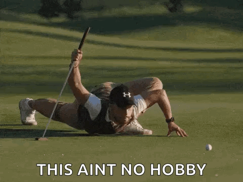 Man Laying on Golf Course Holding Club and Ball