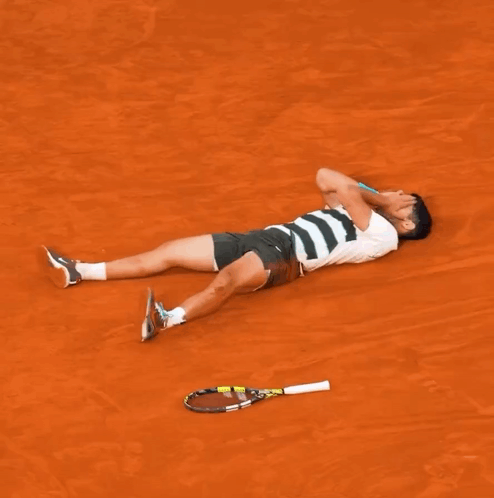 Man Laying on Ground With Tennis Racquet
