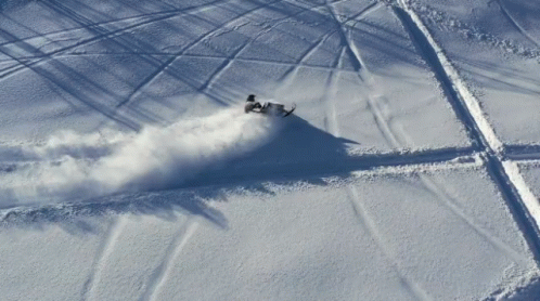 Man Leaving Snowmobile Tracks Aerial View GIF