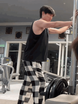 Man Lifting Weights in Plaid Pants and Black Tank