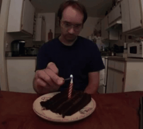 Man Lighting Candle On Cake GIF