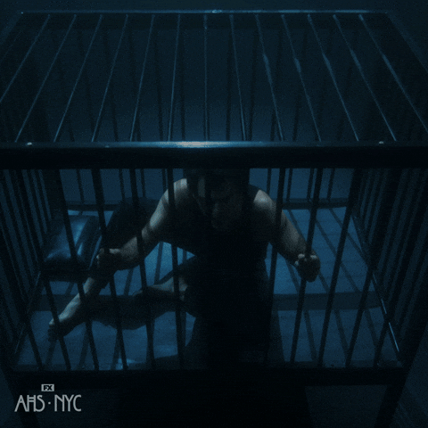Man Locked In Cage In Dark Room GIF