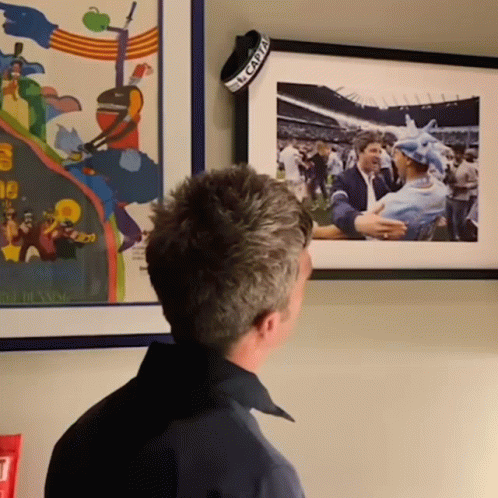 Man Looking at Framed Picture With El Capitan Band