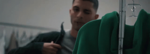 Man Looking at Green Jacket