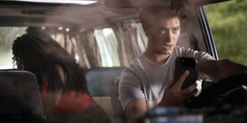 Man Looking at Phone While Driving