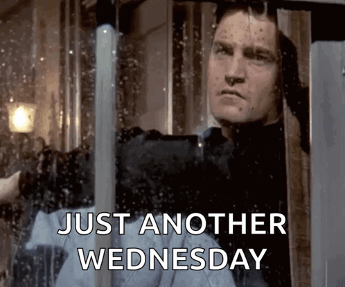 Man Looking Out Window Saying Just Another Wednesday