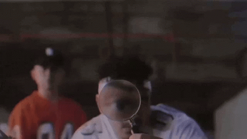 Man Looking Through Magnifying Glass at Another Man's Face