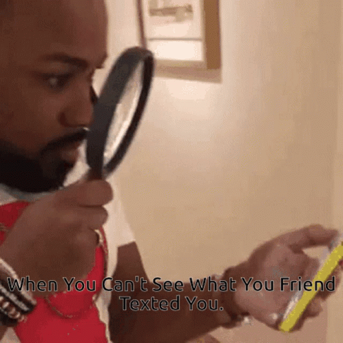 Man Looking Through Magnifying Glass at Phone