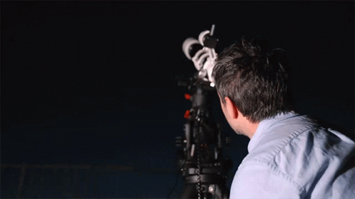 Man Looking Through Telescope at Night Sky