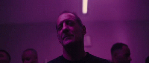 Man Looking Up in Dark Room With Purple Lights