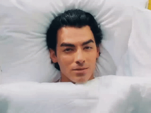 Man Lying In Bed Smiling GIF