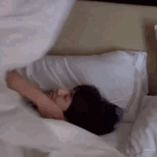 Man Lying in Bed with Pillow on Face
