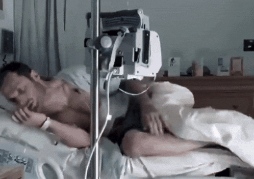 Man Lying in Hospital Bed With IV