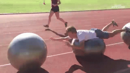 Man Lying on Ball on Track