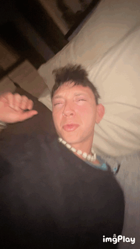 Man Lying On Bed With Necklace GIF