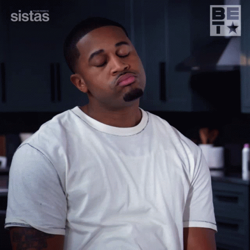 Man Making Face in Front of Sistas Logo