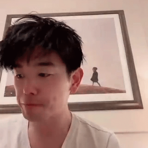 Man Making Funny Face in Front of Framed Picture