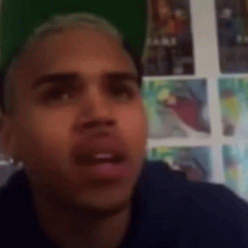 Man Making Funny Face In Front Of Wall With Posters GIF