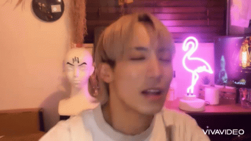 Man Making Funny Face With Flamingo Neon Sign