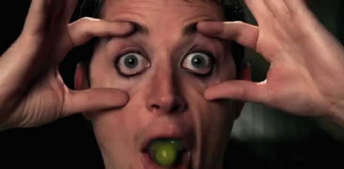 Man Making Funny Face With Grape in Mouth
