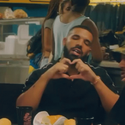 Man Making Heart Shape With Hands at Table