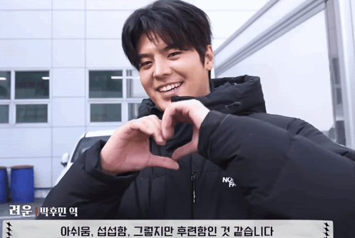 Man Making Heart With Hands in Front of Building