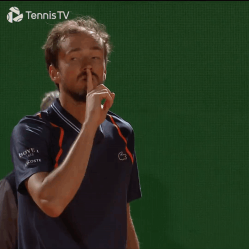 Man Making Shhh Gesture in Front of Tennis TV Logo