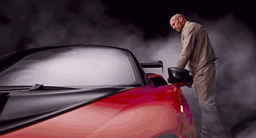 Man Next to Red Sports Car With Smoke