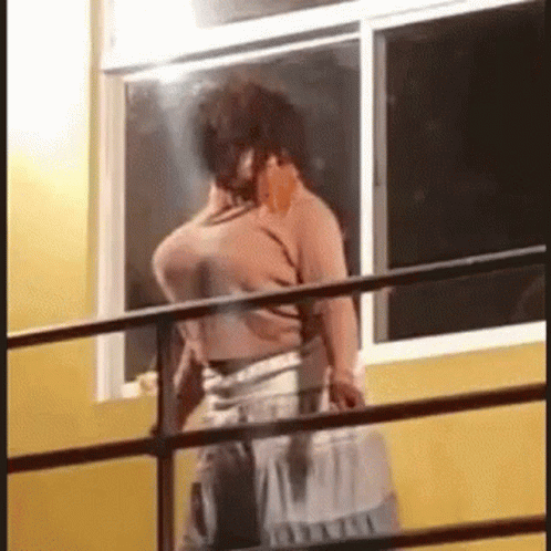 Man on Balcony Talking on Cell Phone