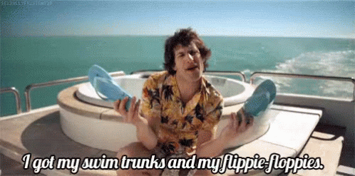 Man On Boat Holding Flip Flops Saying I Got My Swim Trunks GIF