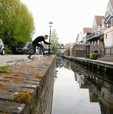 Man On Brick Wall Next To River GIF