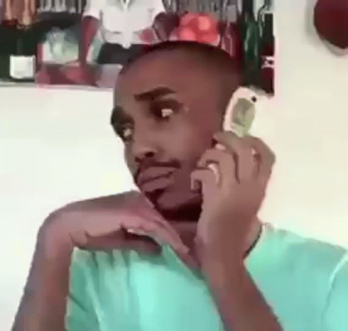 Man on Cell Phone in Front of Man's Picture
