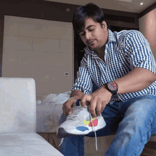 Man on Couch Tying Shoe With Rolex Watch