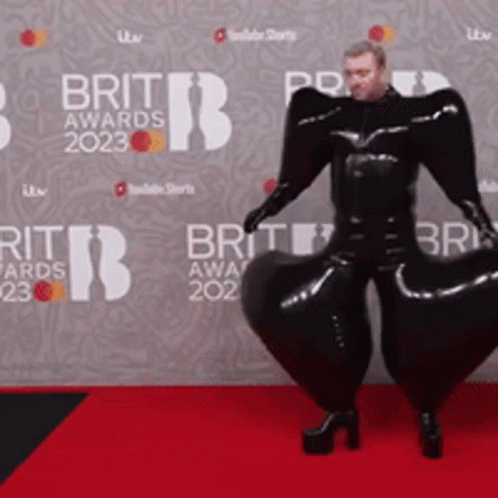 Man on Red Carpet in Front of Brit Awards Wall