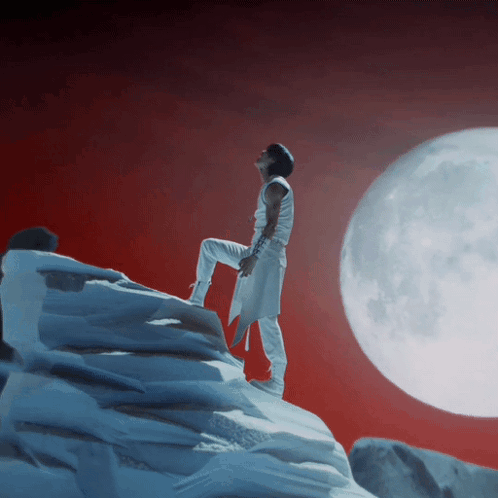 Man On Snowy Mountain With Full Moon GIF