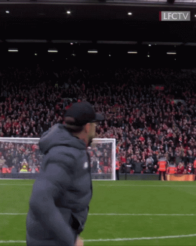 Man on Soccer Field in Front of Crowd With LFCTV