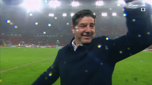 Man On Soccer Field With Arms In Air And BT Logo GIF