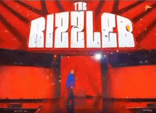 Man on Stage in Front of Red Ripple Sign
