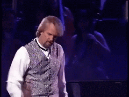 Man On Stage In Vest And Bow Tie GIF
