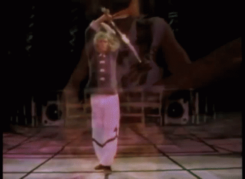 Man on Stage With Arms Outstretched Before Crowd