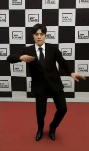 Man On Suit Dancing Against Checkered Wall GIF