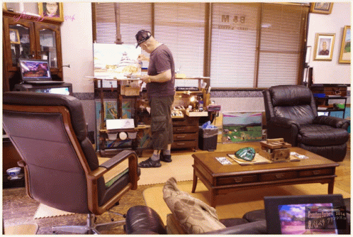 Man Painting In Living Room With Hotel & Cafe Sign GIF