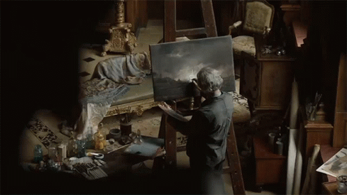 Man Painting on Canvas in Dark Room