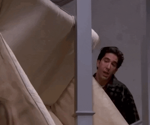 Man Peeking Behind Couch Says Pivot GIF
