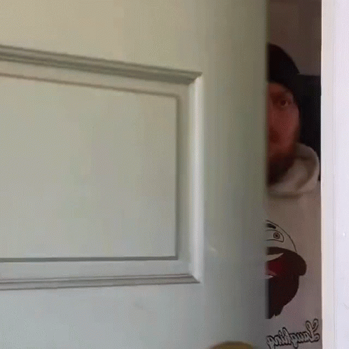 Man Peeking from Behind Door with Picture