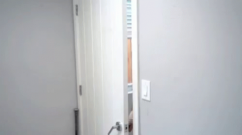 Man Peeking Out From Behind Door GIF